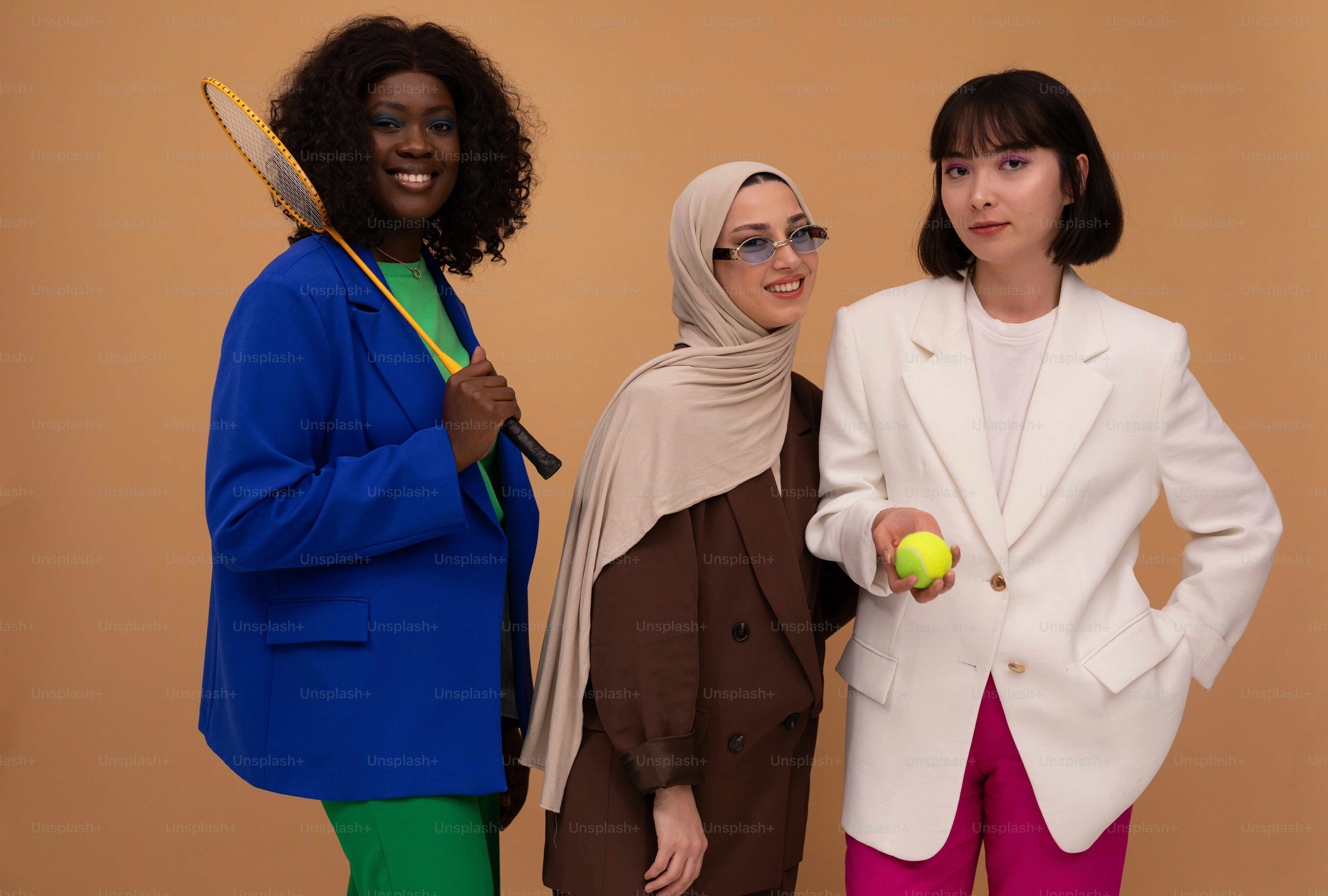 three women standing next to each other holding tennis rackets