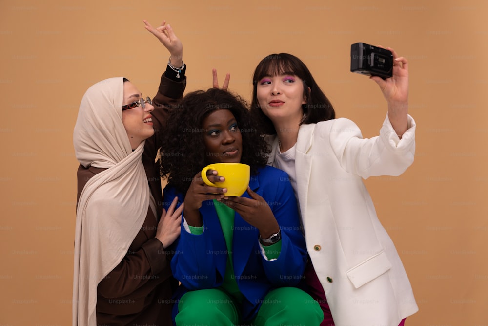 three women taking a picture with their cell phones
