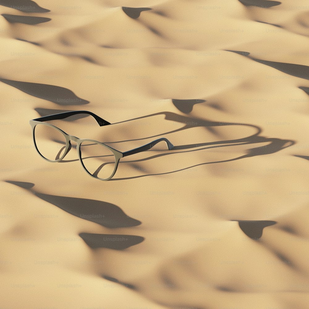 a pair of glasses laying on top of a desert