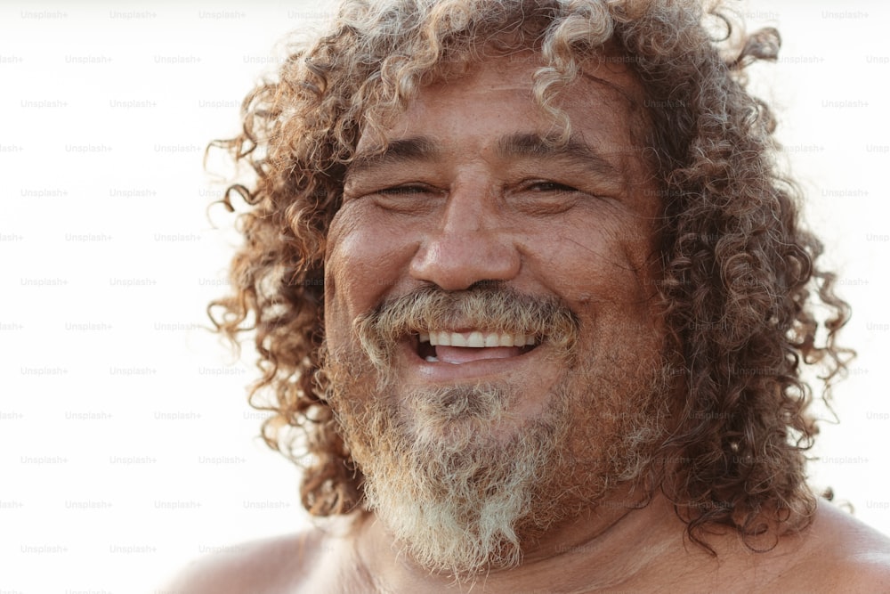 um homem com cabelos encaracolados e barba sorrindo