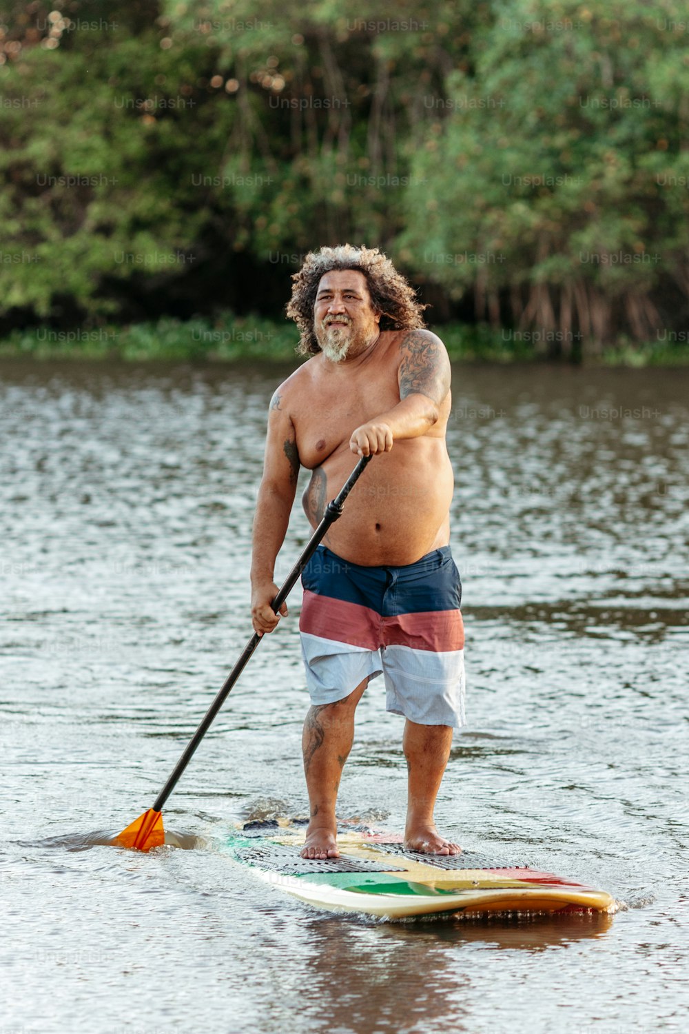 a man riding a paddle board on top of a lake