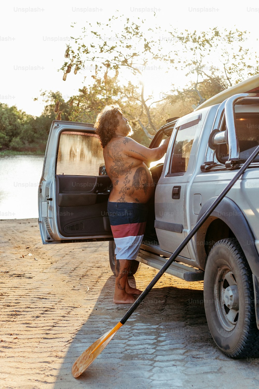 a man standing next to a truck with a paddle