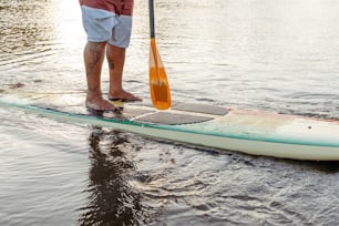 a man standing on a paddle board in the water