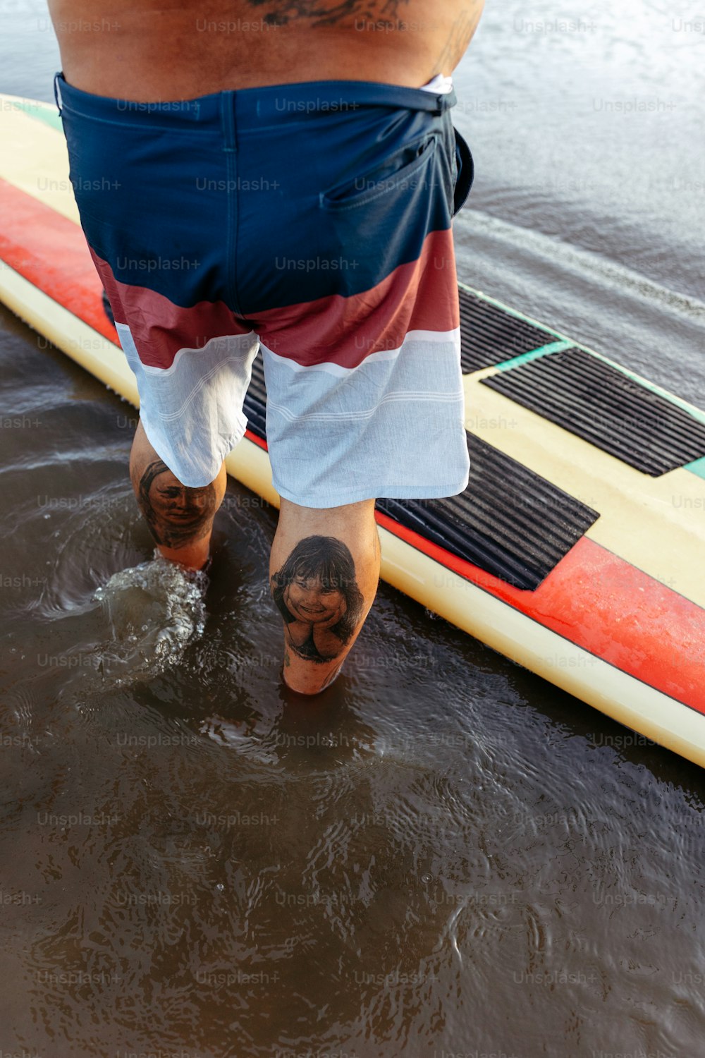 Un hombre parado encima de una tabla de surf en el agua