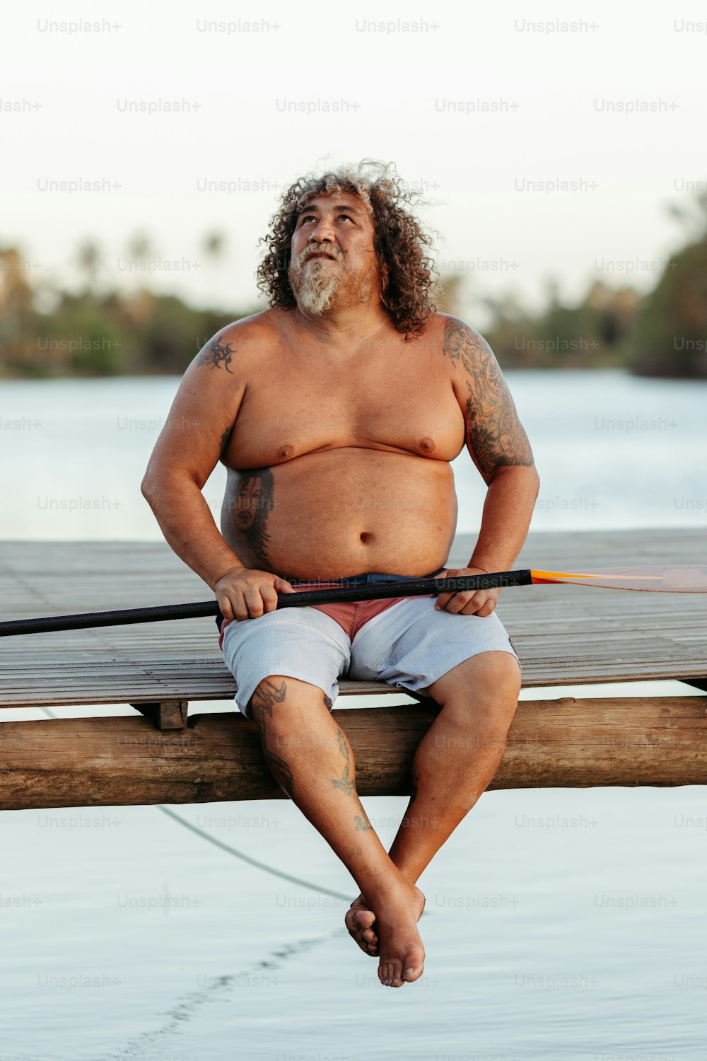 a man sitting on a dock with a paddle