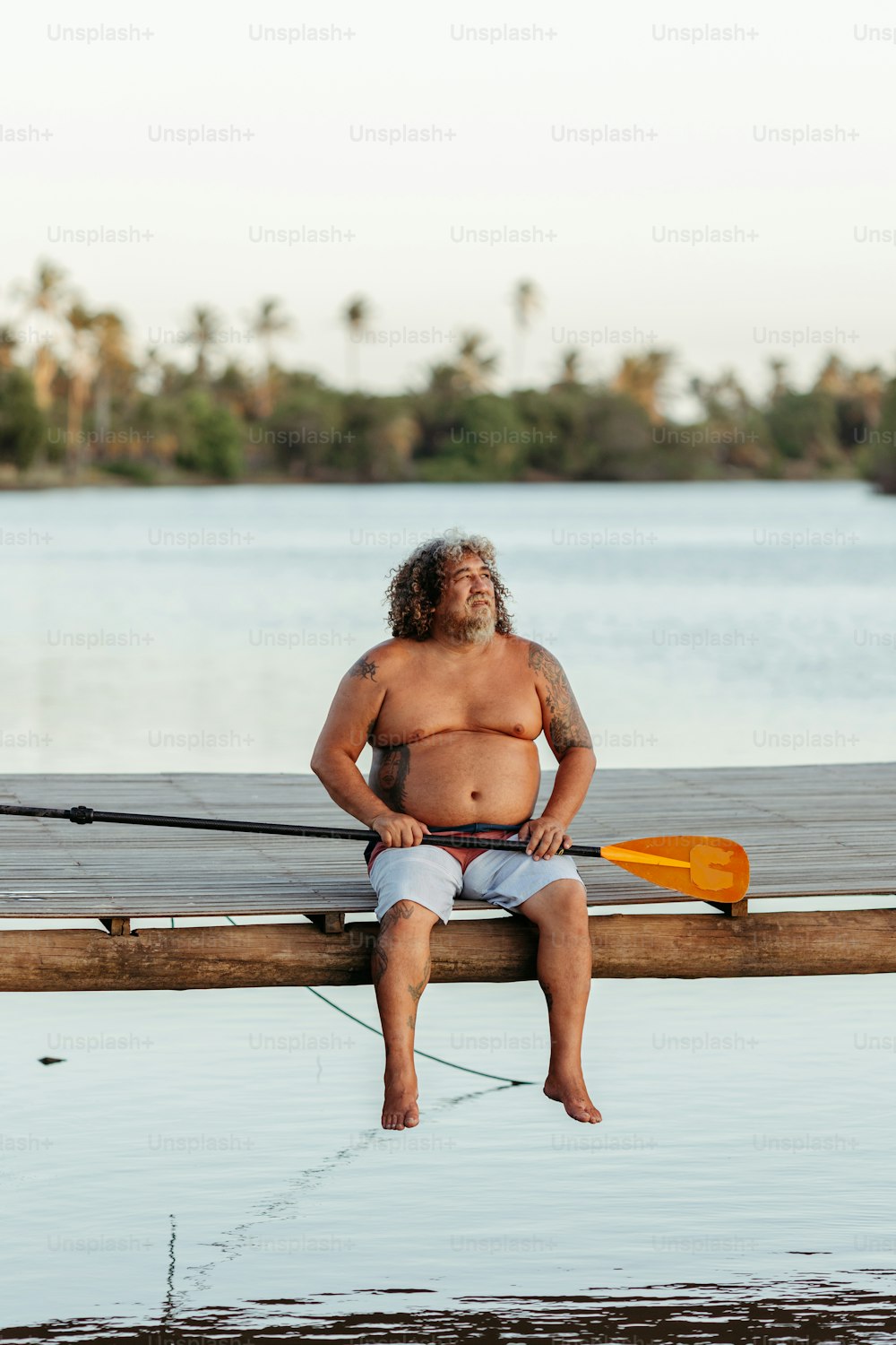 Un hombre sentado en un muelle con un kayak