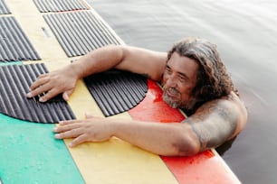 a man laying on top of a surfboard in the water