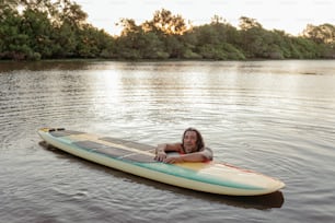 Un uomo sdraiato su una tavola da surf nell'acqua
