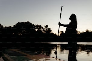 a woman standing on a paddle board in the water