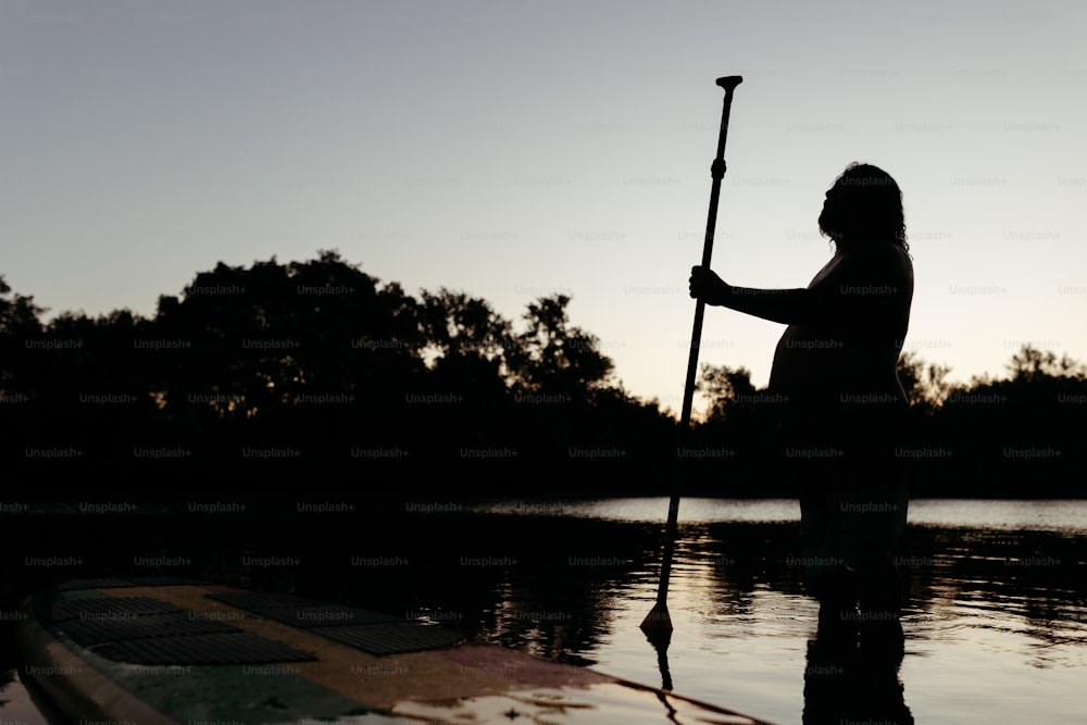 水中のパドルボードの上に立つ女性