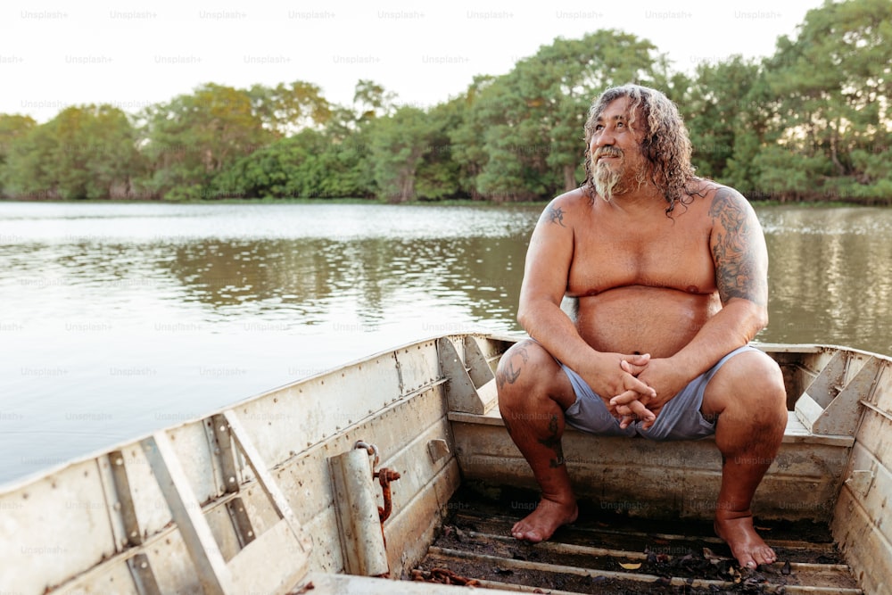 um homem sentado na parte de trás de um barco em um lago