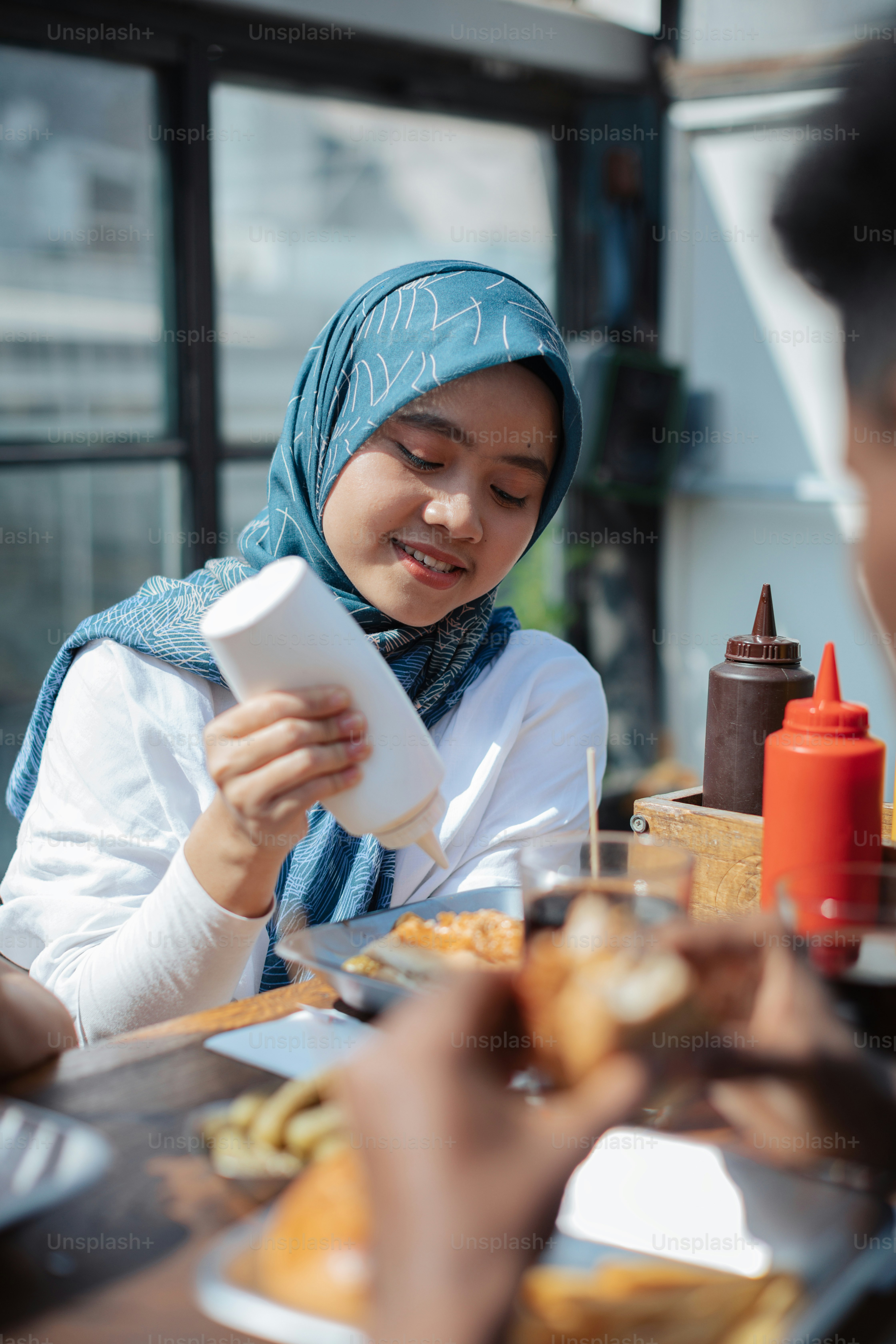 a woman sitting at a table with a plate of food