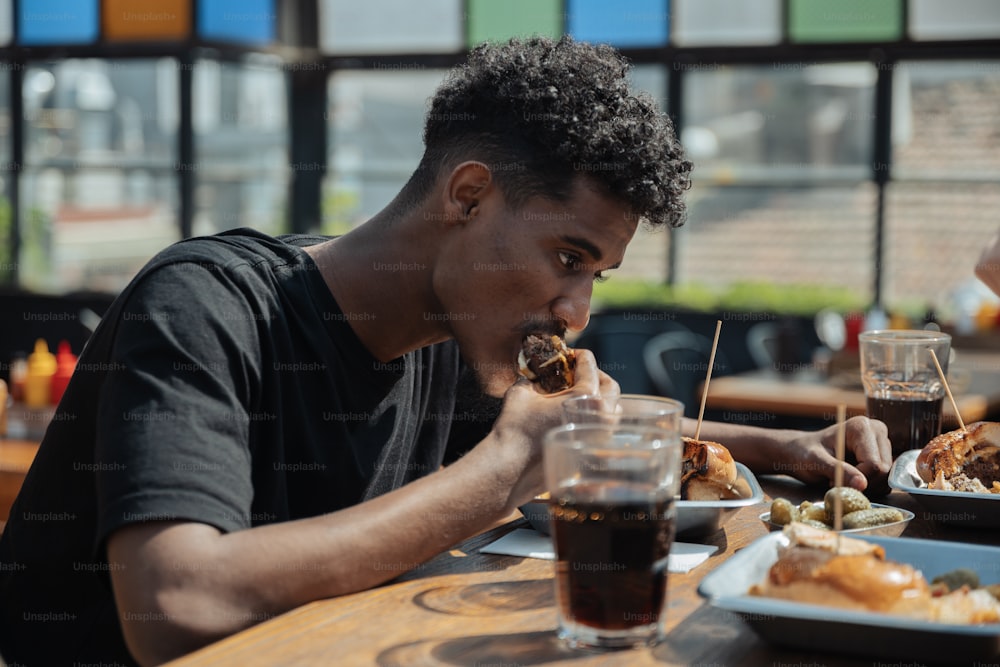Un hombre sentado en una mesa comiendo alimentos