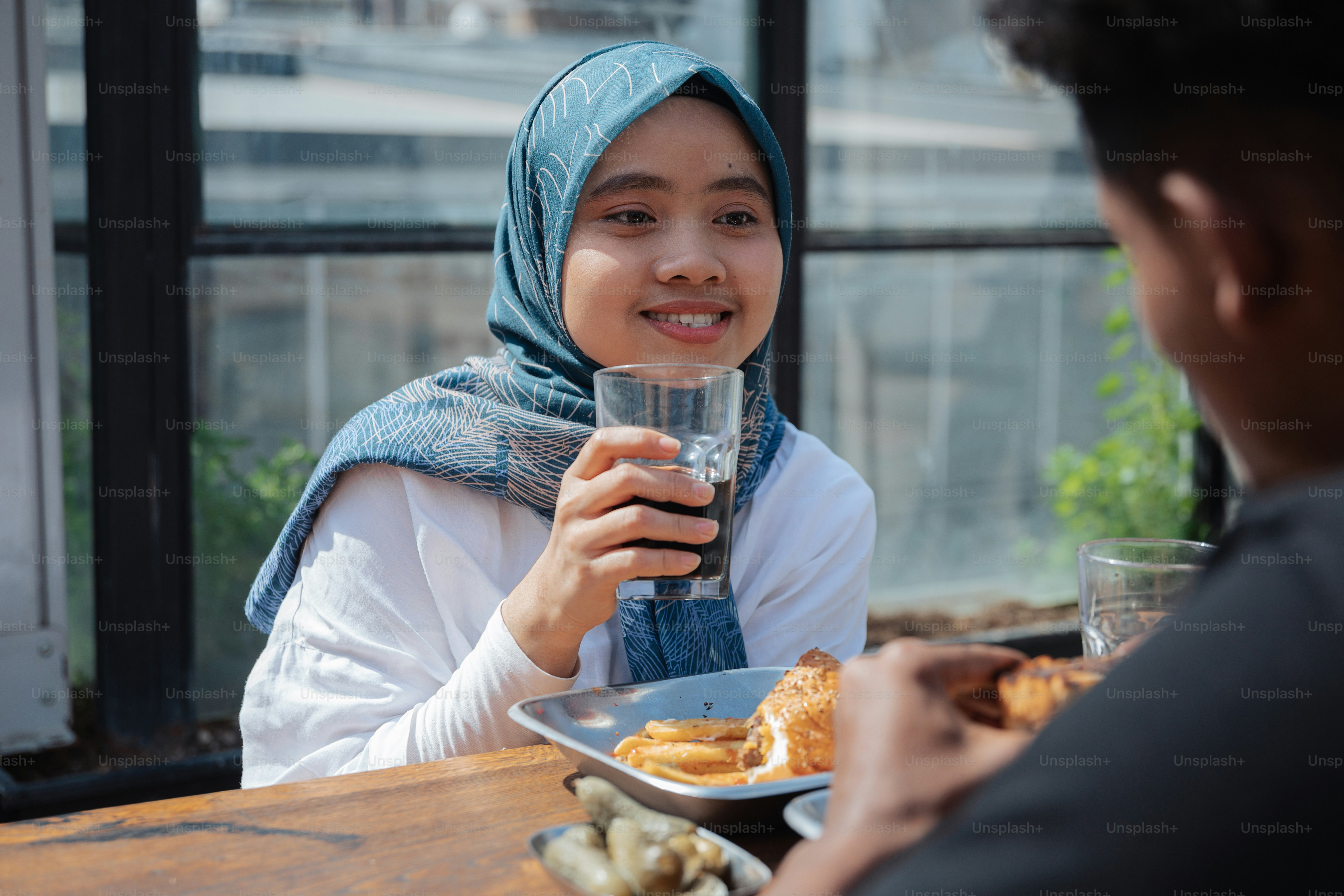a woman sitting at a table with a plate of food