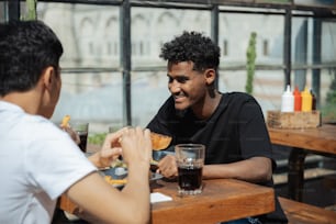 a couple of men sitting at a table eating food