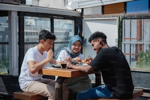 a group of people sitting at a table eating food