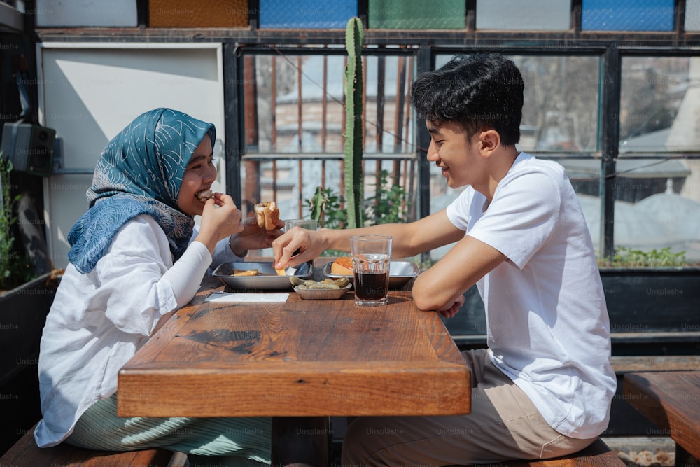 Un homme et une femme assis à une table en train de manger