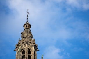 a tall clock tower with a weather vane on top