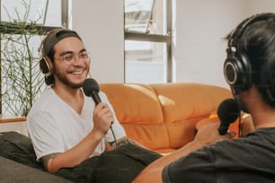 a man sitting on a couch holding a microphone