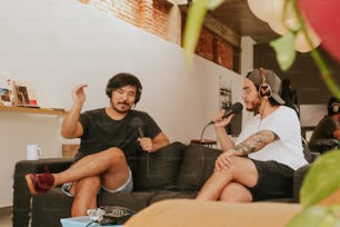 a couple of men sitting on top of a couch