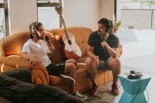 a couple of men sitting on top of a couch