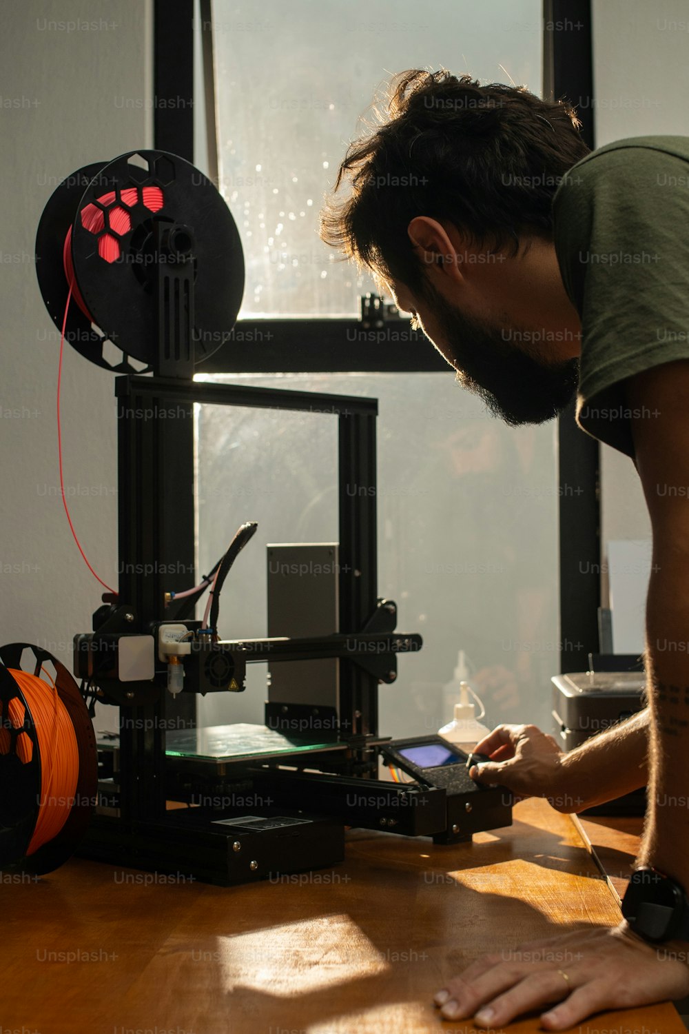 Un hombre está trabajando en una impresora 3D