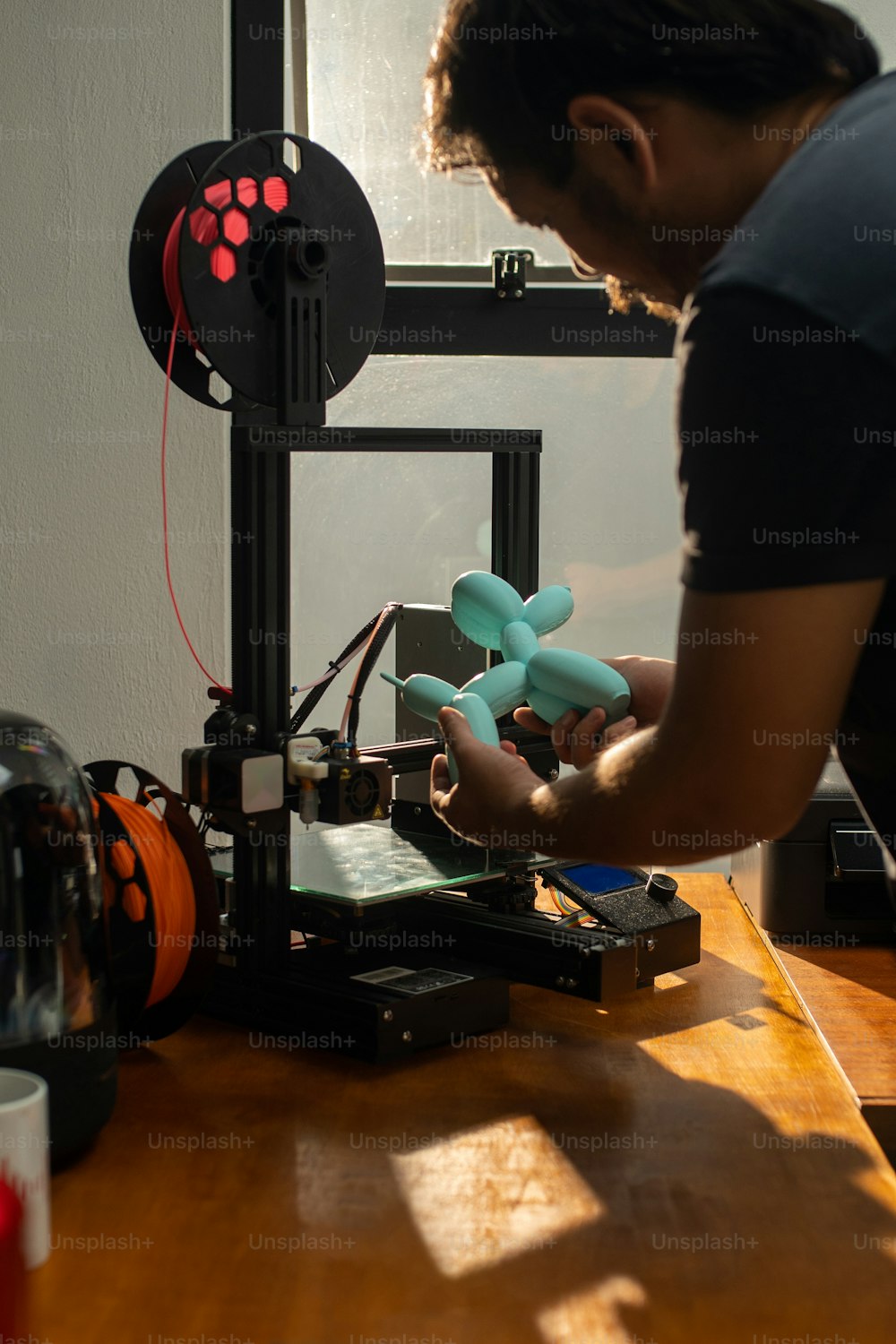 한 남자가 3D 프린터에서 작업하고 있다