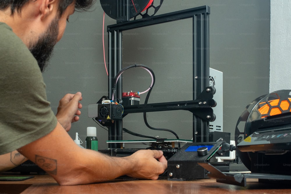 Un uomo sta lavorando su una stampante 3D