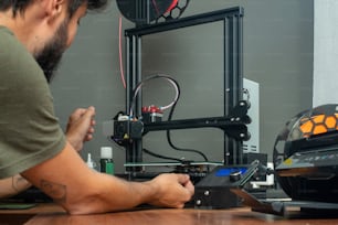 Un hombre está trabajando en una impresora 3D