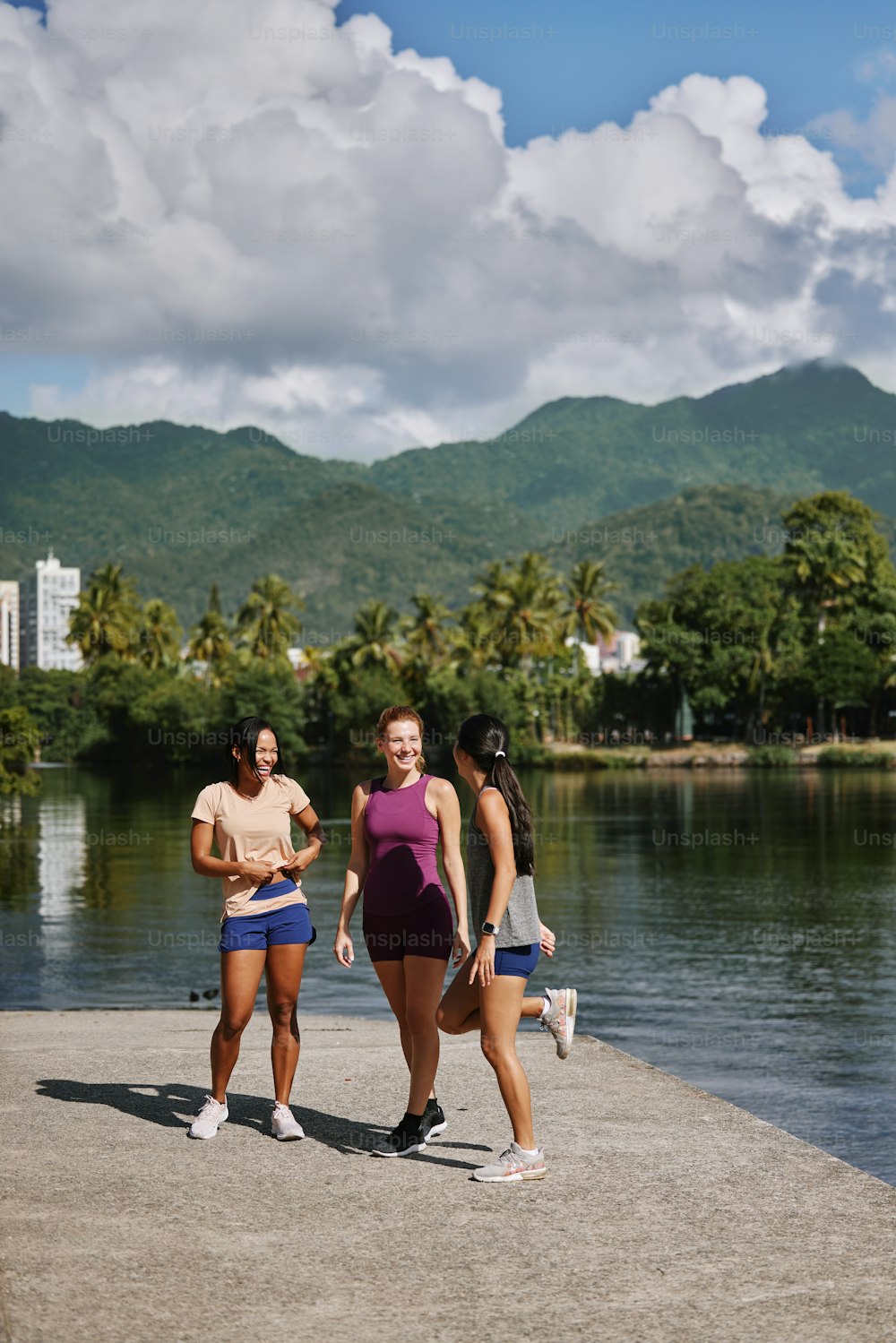 a group of women standing next to a body of water