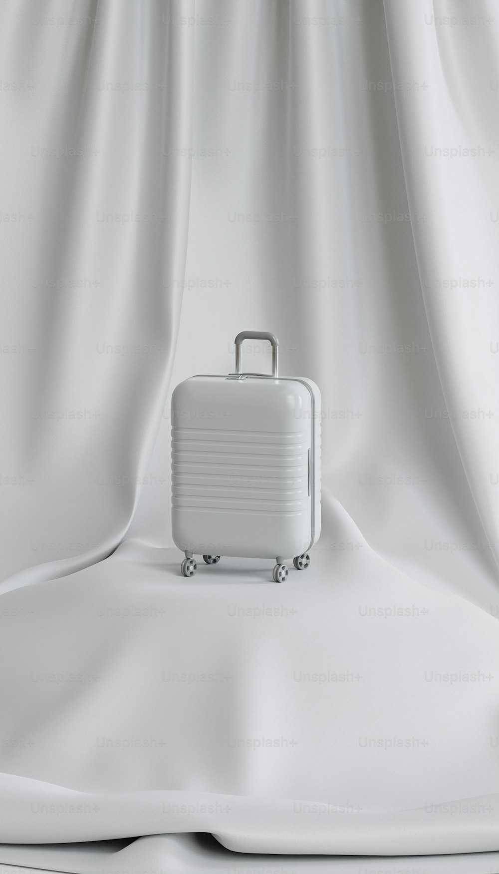 una valigia bianca seduta sopra un lenzuolo bianco
