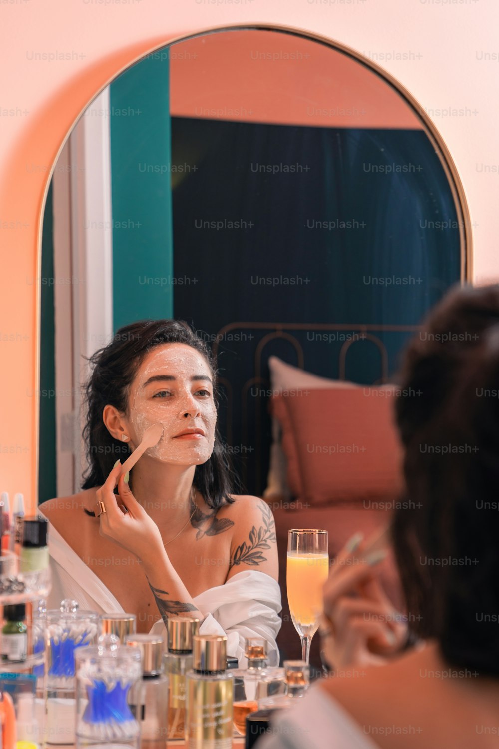 a woman sitting at a table in front of a mirror