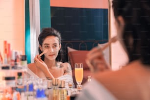 Una mujer mirándose a la cara en el espejo