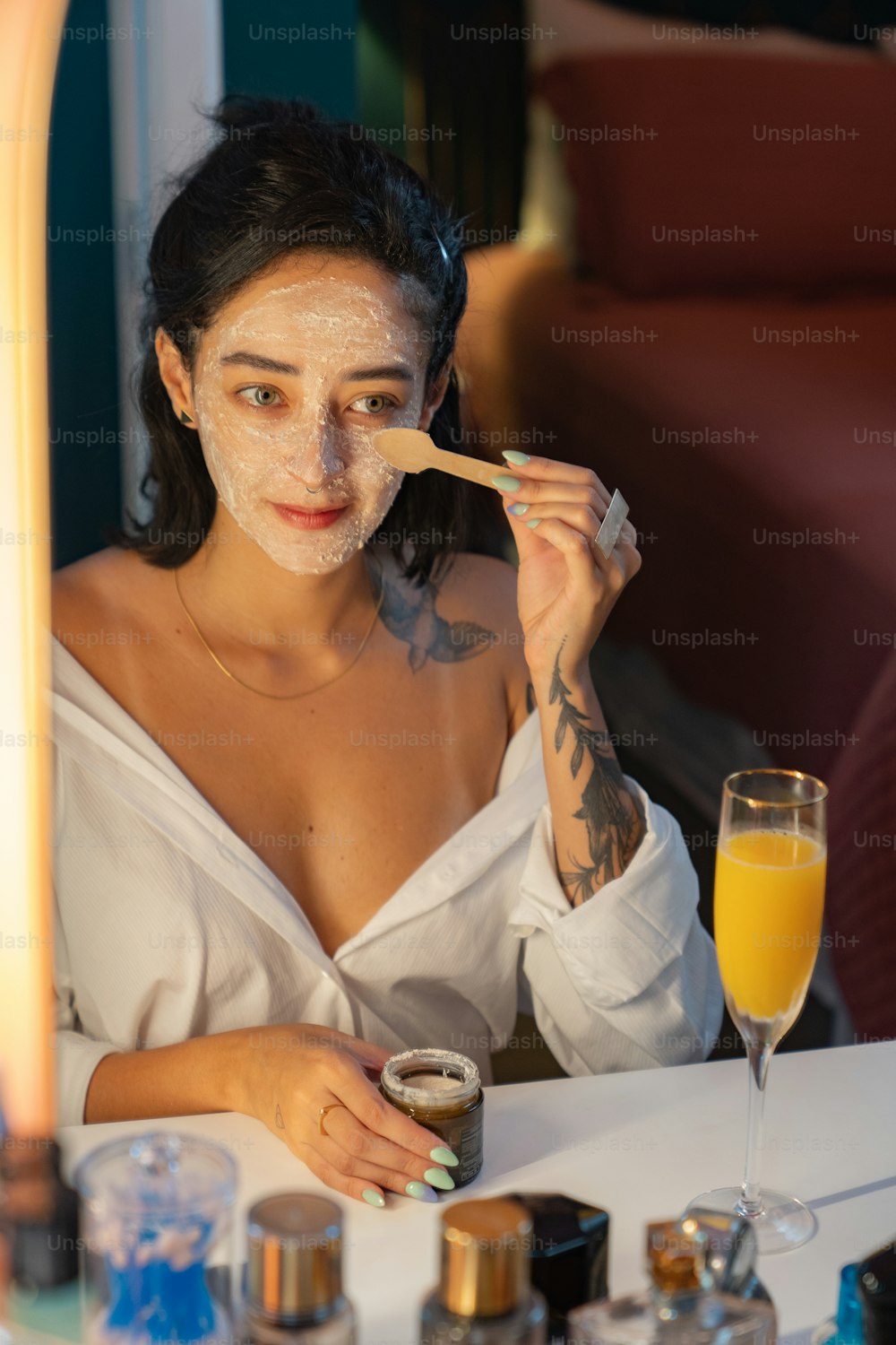 eine Frau, die mit einem Glas Orangensaft an einem Tisch sitzt