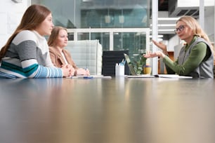 a group of women sitting around a table talking