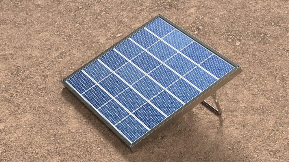 Un pequeño panel solar sentado encima de un campo de tierra