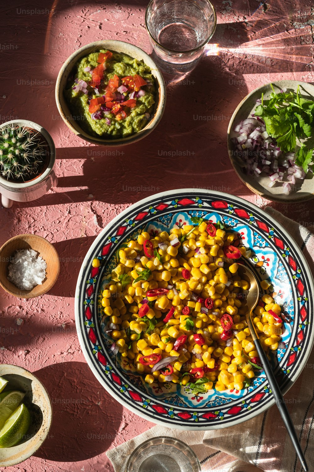 a bowl of corn and a bowl of guacamole on a table