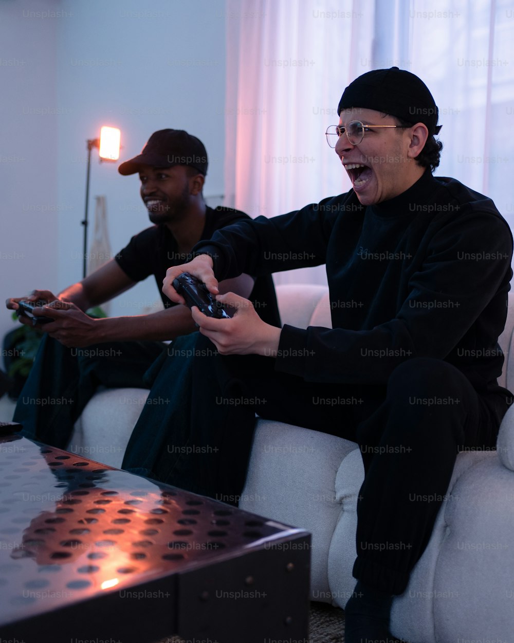 소파에 앉아 비디오 게임을 하는 두 사람