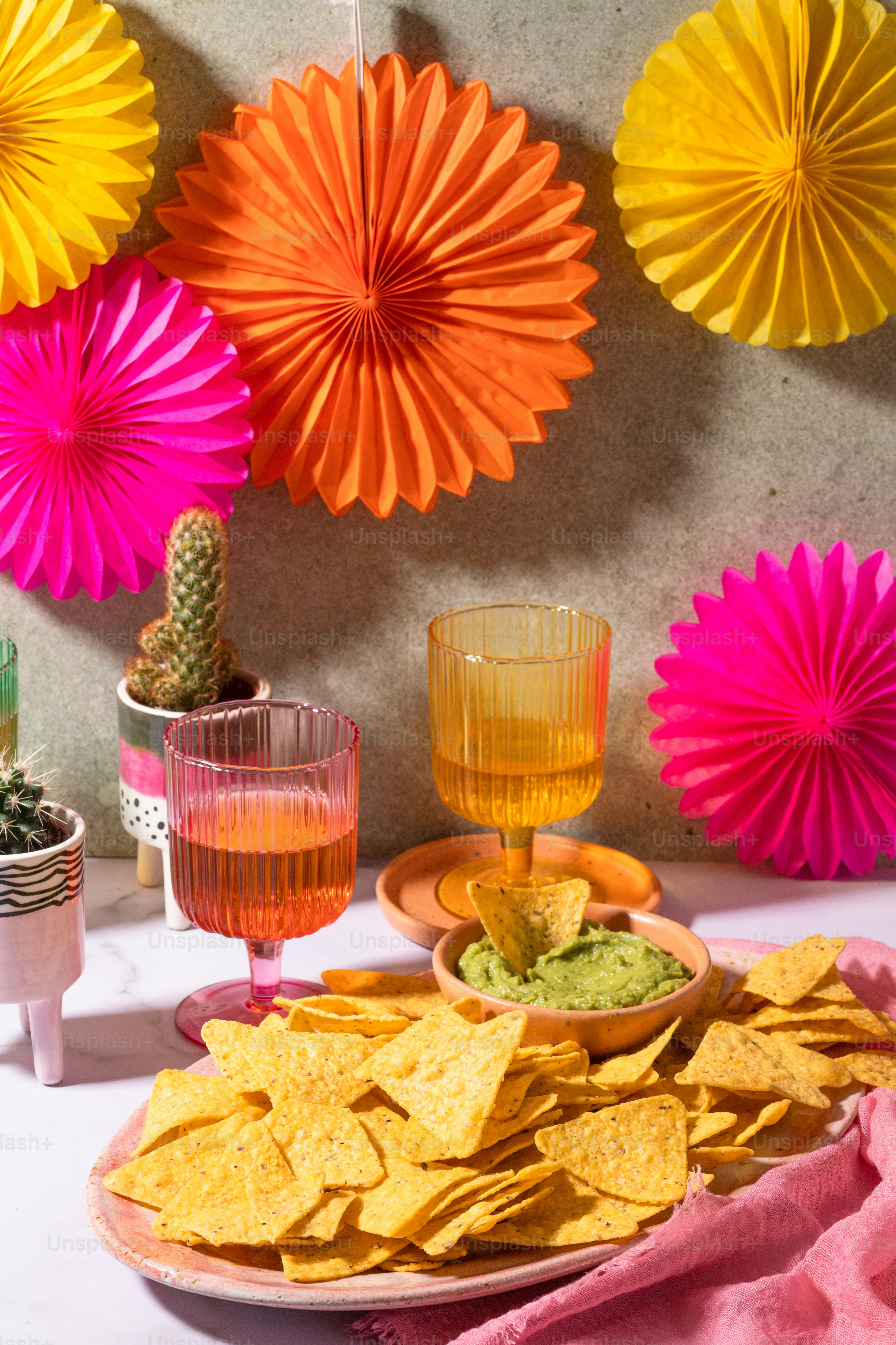 a table topped with a plate of chips and a bowl of guacamole