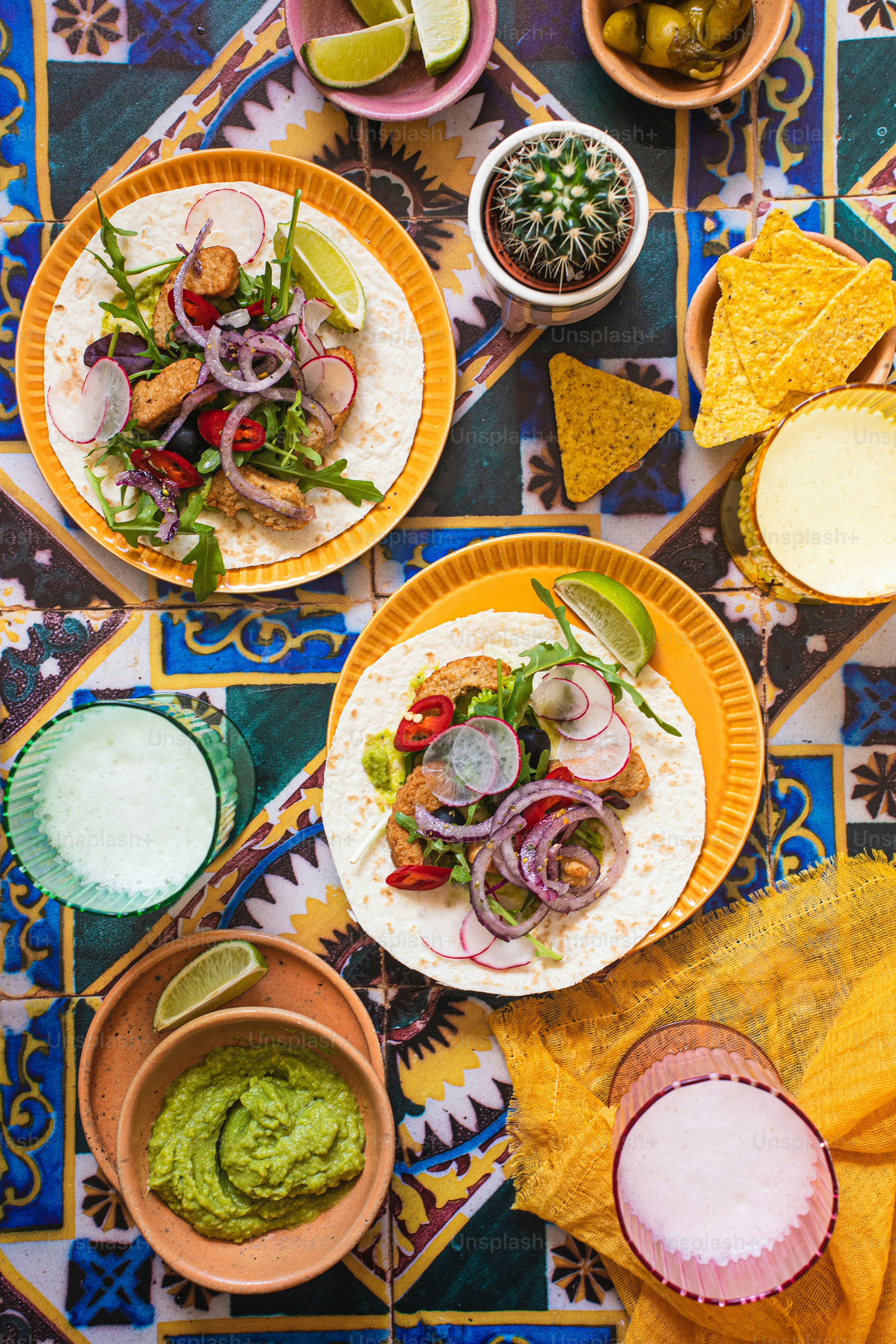 A table topped with lots of tacos covered in toppings photo – Food ...