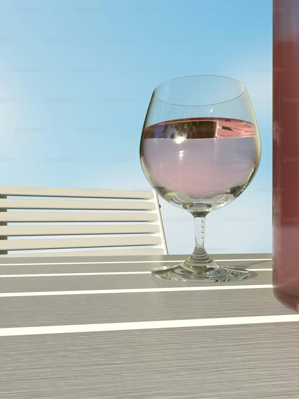 um copo de vinho sentado em cima de uma mesa de madeira