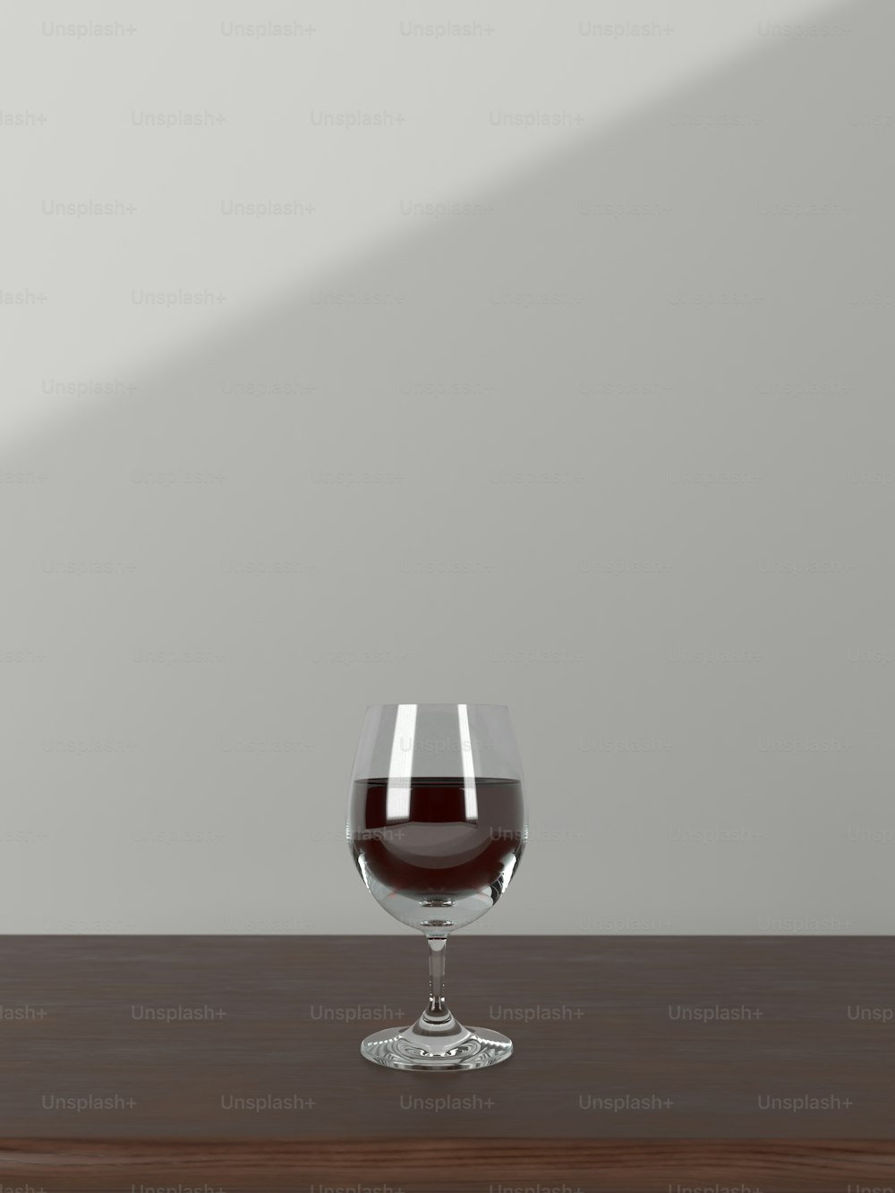 um copo de vinho sentado em cima de uma mesa de madeira