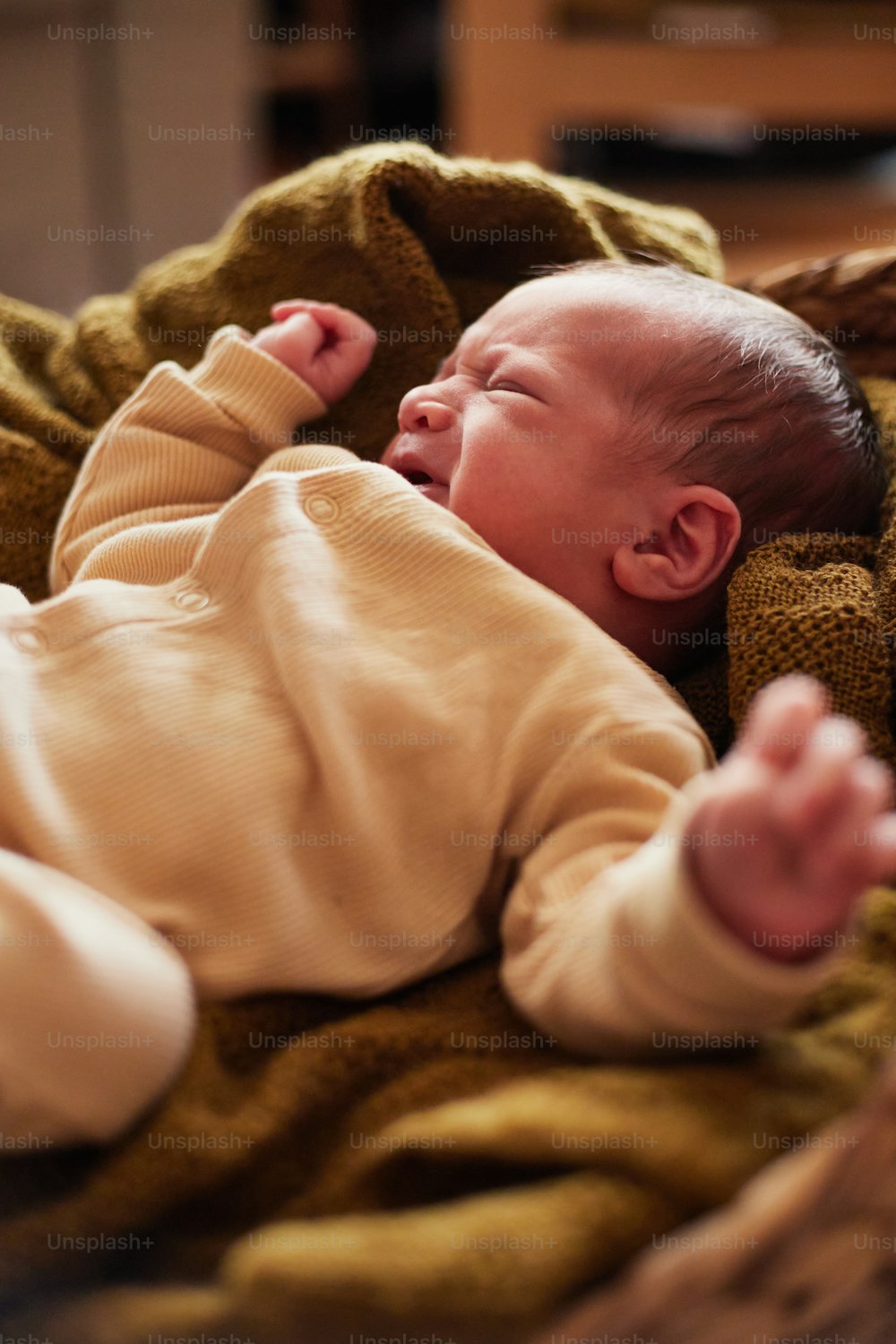 Ein Baby legt sich auf eine Decke