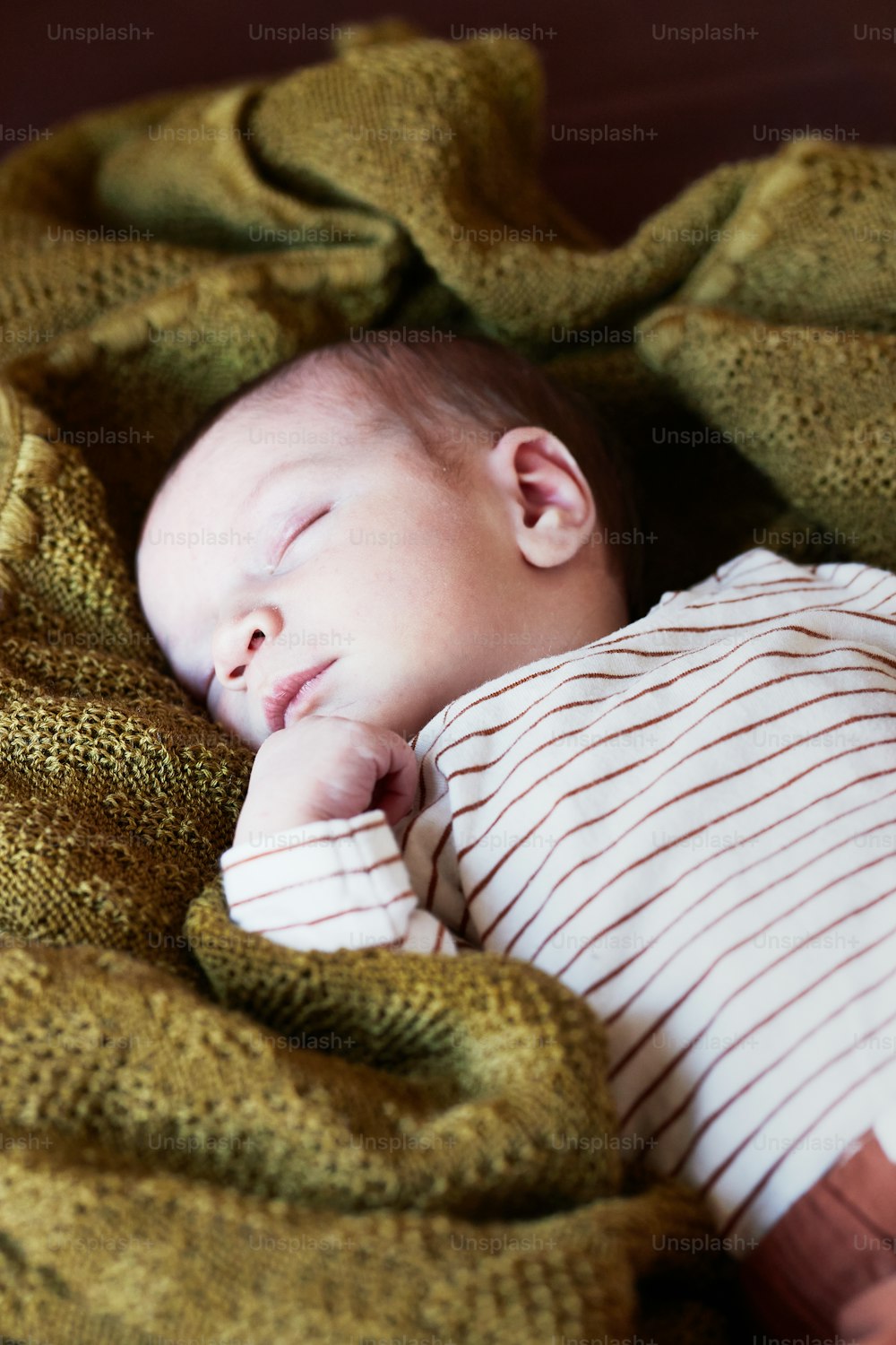 小さな赤ちゃんが毛布の上で寝ている