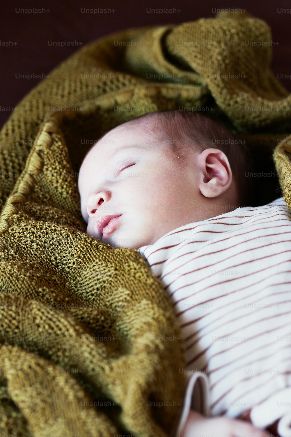 Un bambino piccolo dorme su una coperta