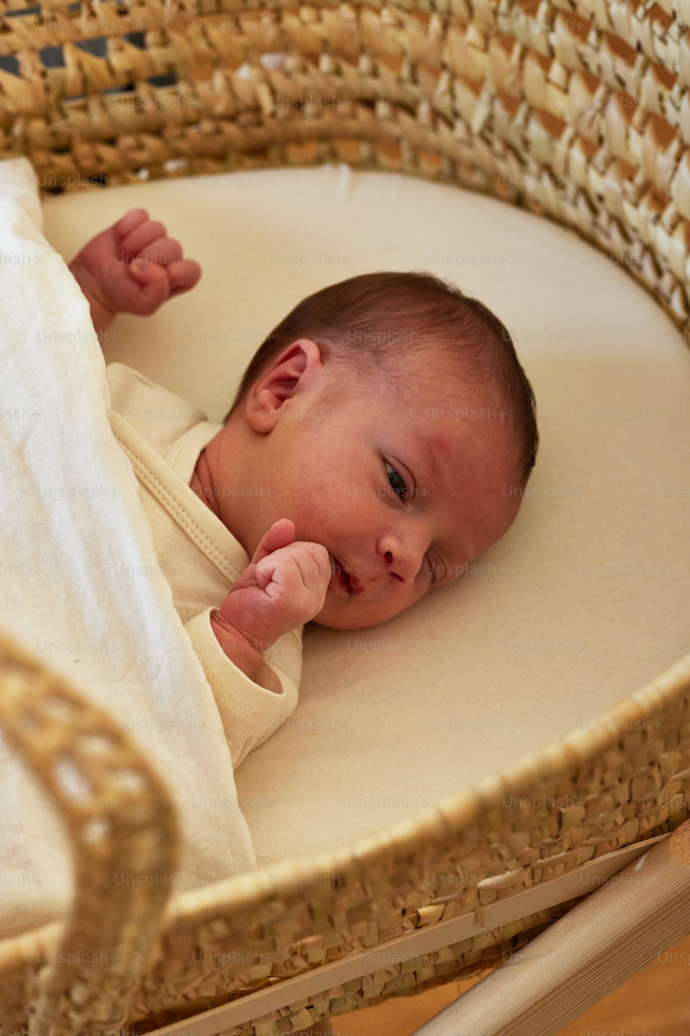 um bebê está deitado em uma cesta de vime