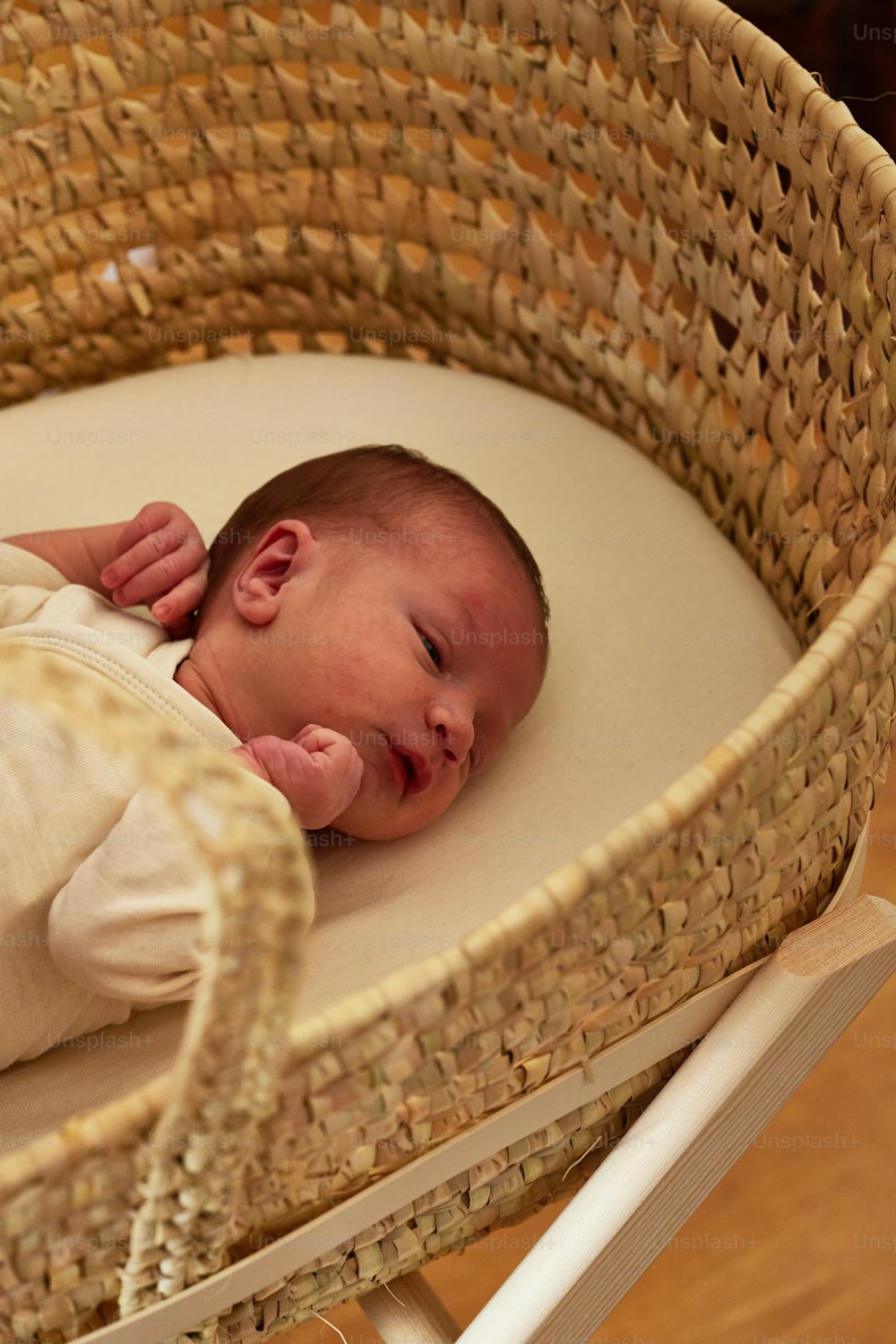 um bebê está dormindo em uma cesta de vime