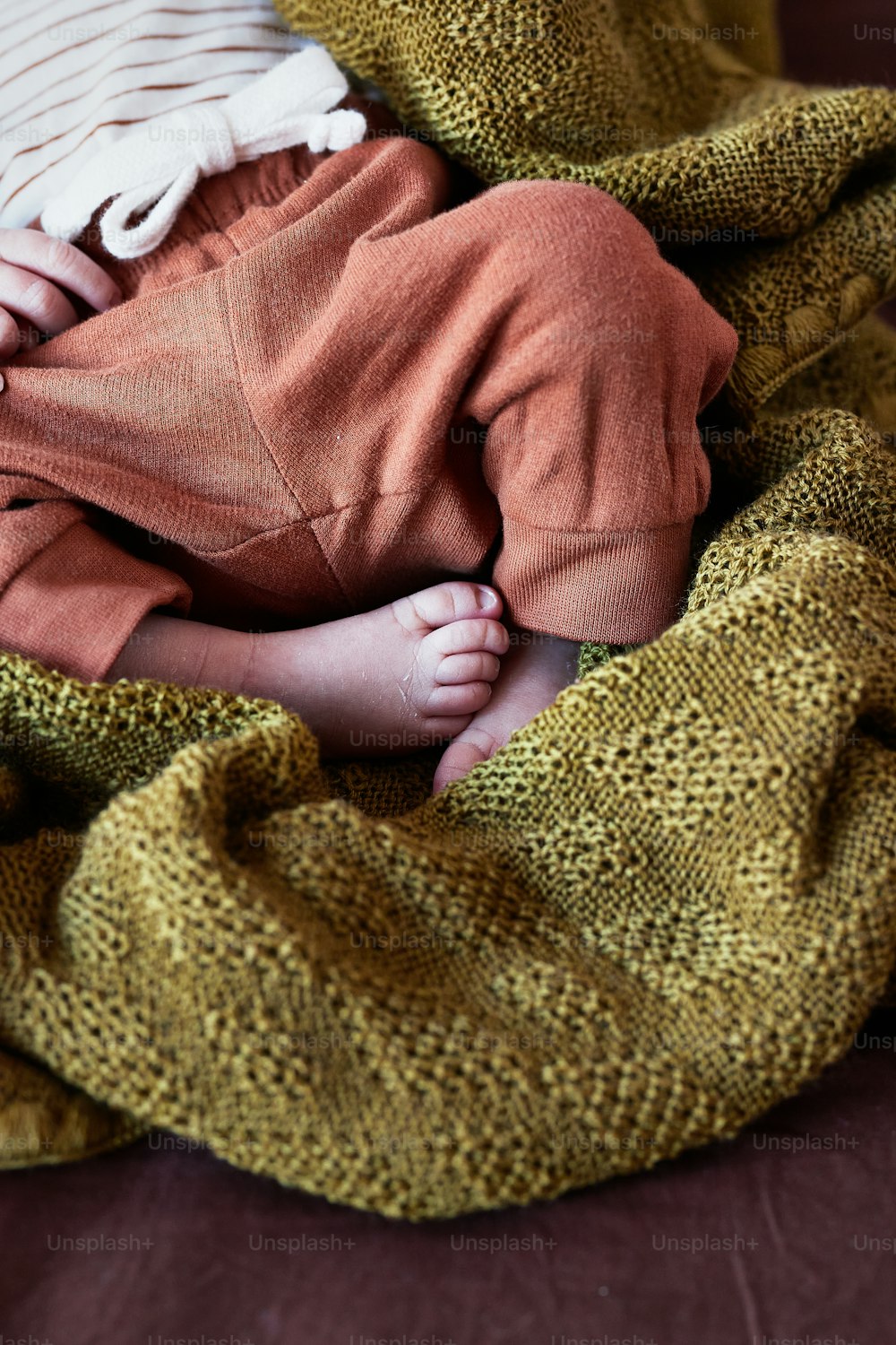 Un bébé enveloppé dans une couverture sur un canapé