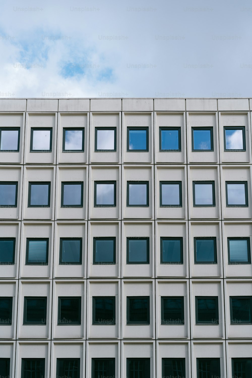 a tall building with lots of windows and a sky background