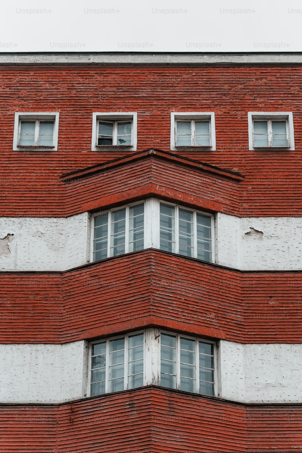 a red brick building with white windows and a clock